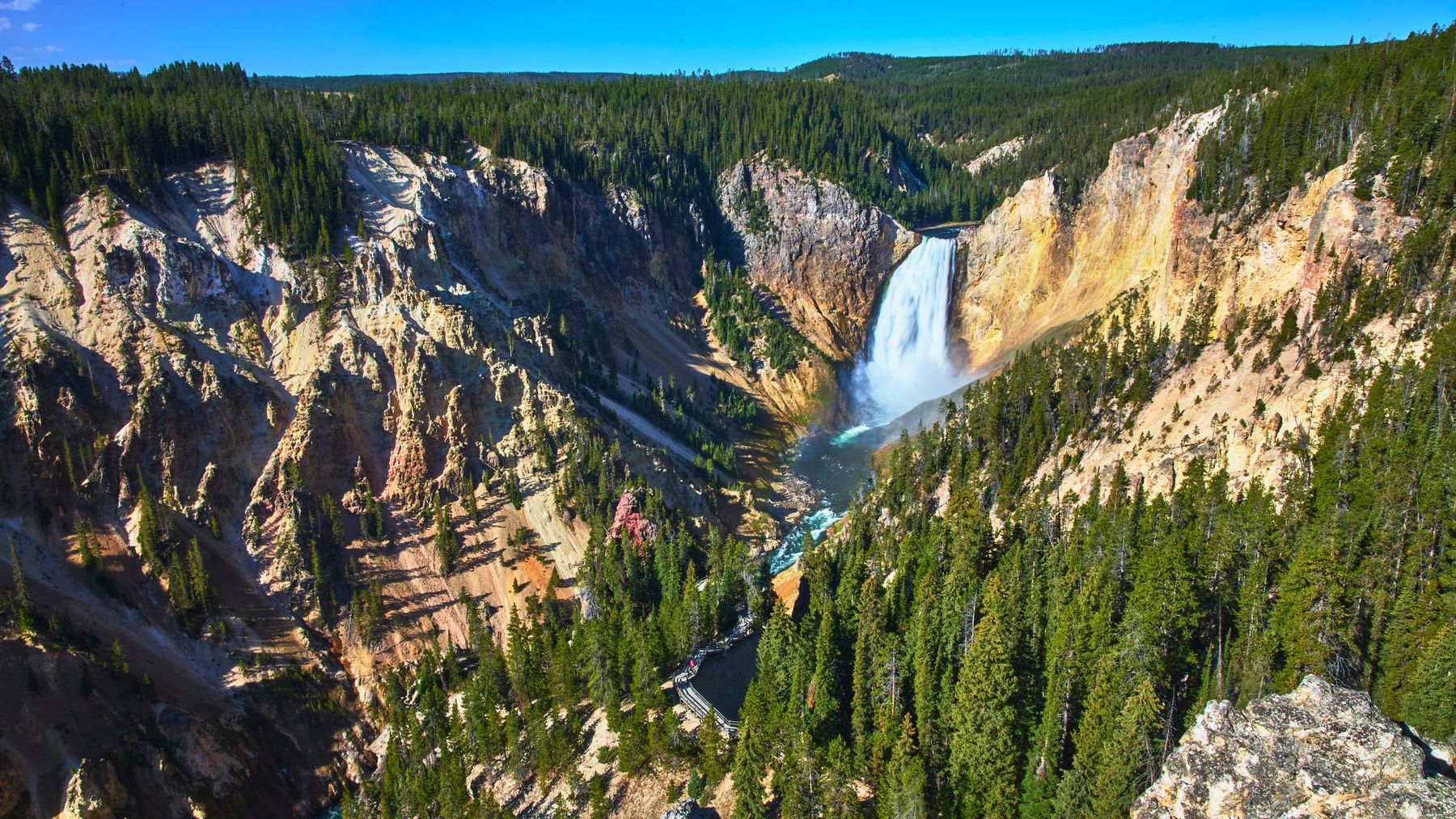 Canyonwand mit farbigen Gesteinsschichten und Wasserfall